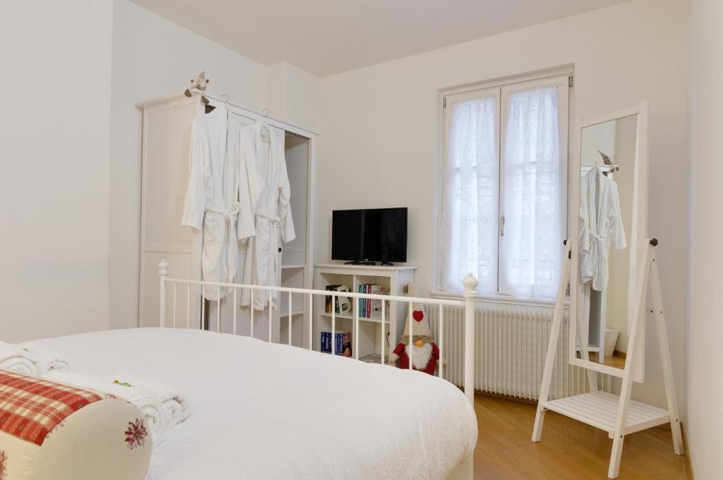 a white bedroom with a bed and a window at B&B and Apartments Al Duomo in Trento
