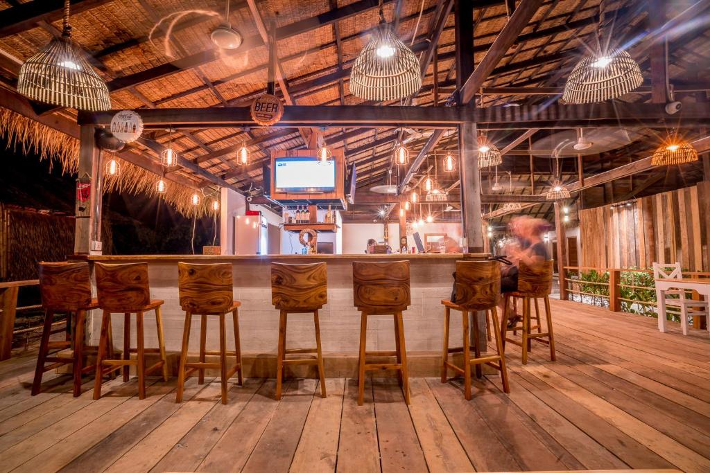 a bar with wooden stools in a room at Sara Resort in Koh Rong Sanloem
