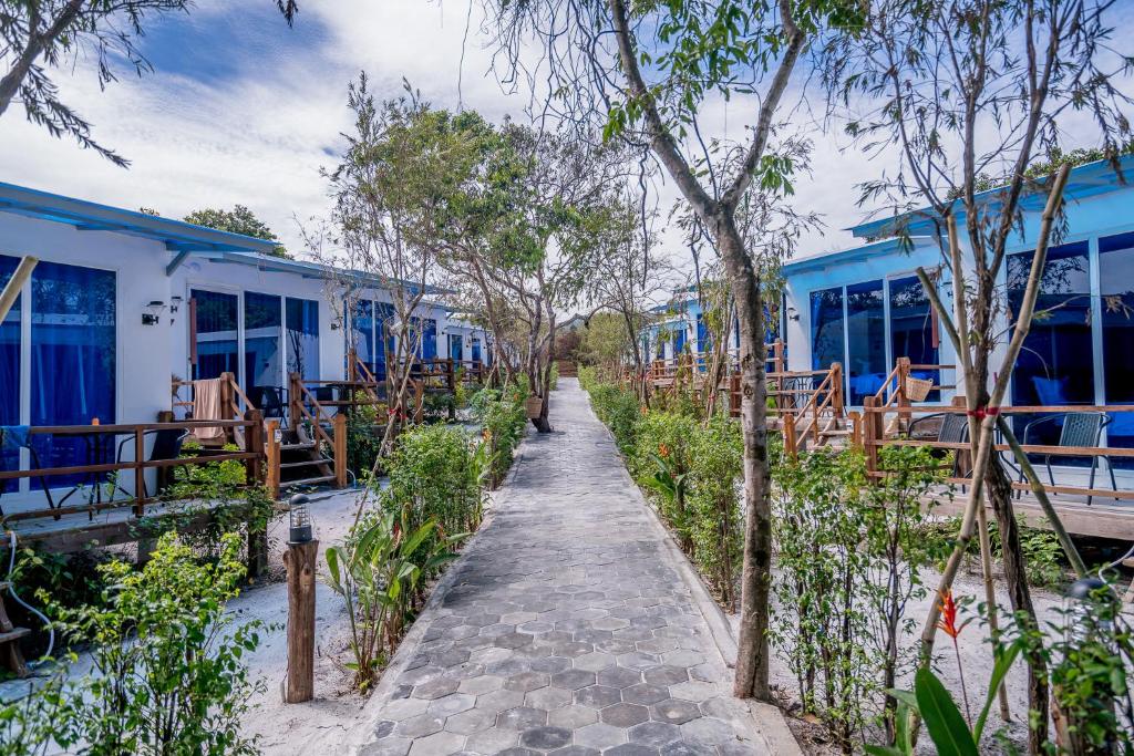 a walkway leading to a row of blue buildings at Sara Resort in Koh Rong Sanloem