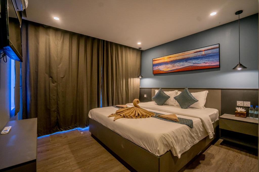 a bedroom with a bed with a painting on the wall at Sara Resort in Koh Rong Sanloem