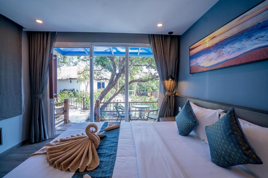 a bedroom with a large bed with a large window at Sara Resort in Koh Rong Sanloem