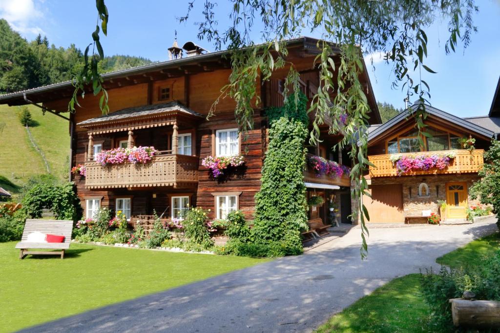 una grande casa in legno con fiori nel cortile di Moabauer a Wagrain