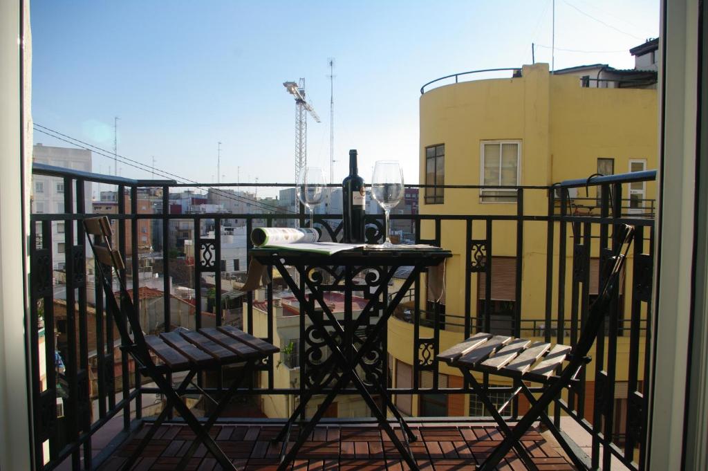 a balcony with two chairs and a table with wine glasses at Carlos & Ana in Valencia