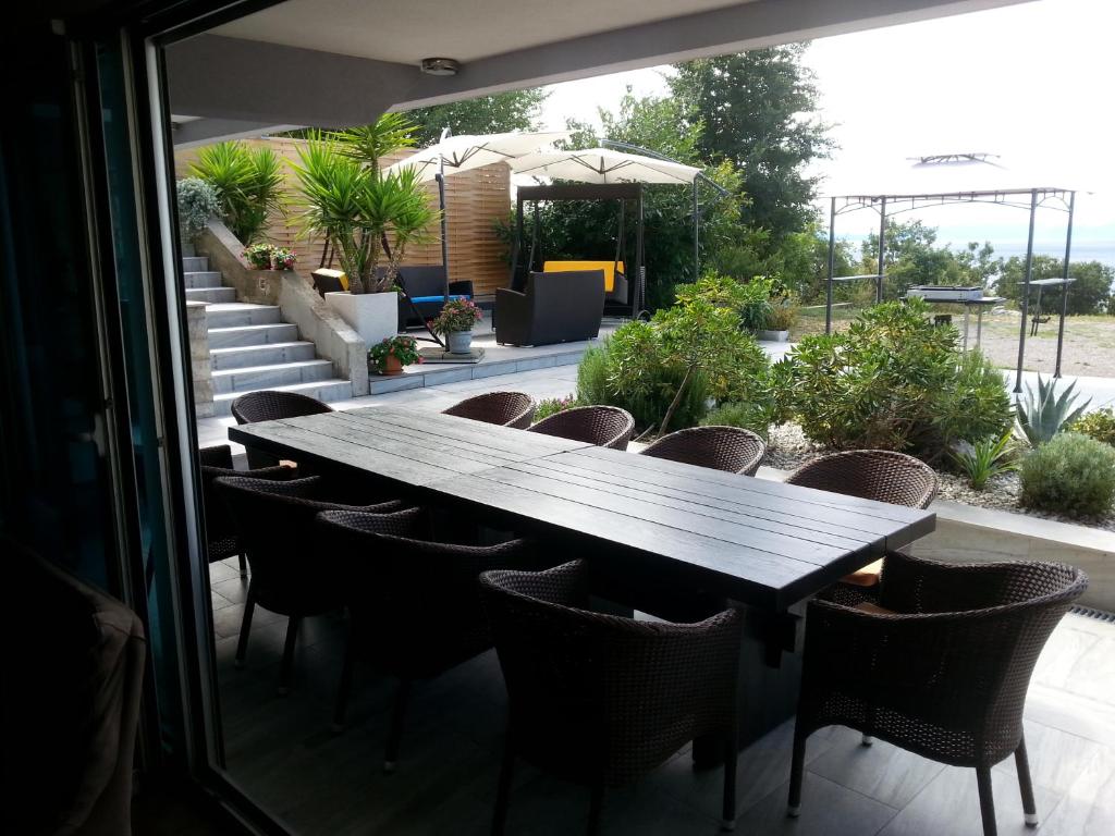 a wooden table and chairs on a patio at Apartment Nella Kostrena in Kostrena