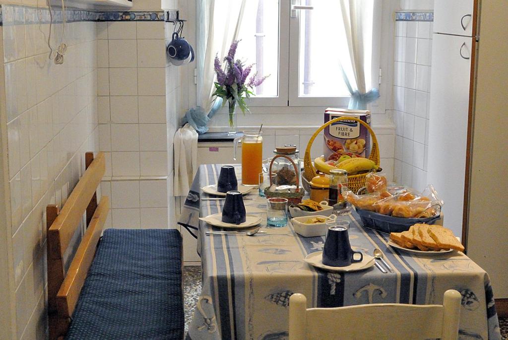 una cucina con tavolo e cibo di B&B Blue Home a Genova