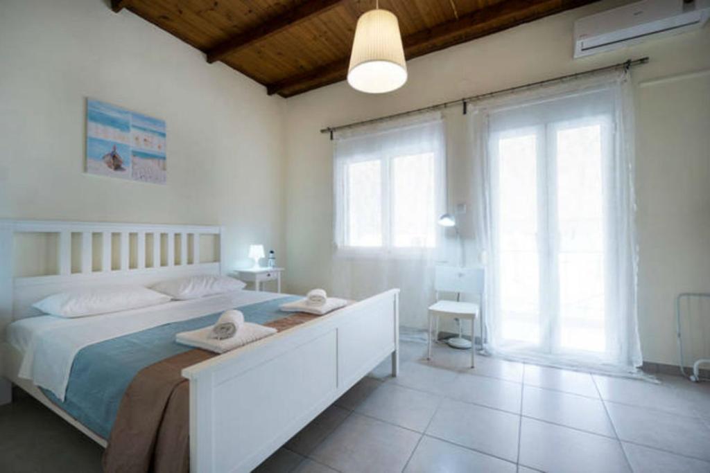 - une chambre avec un grand lit blanc et des serviettes dans l'établissement Kd's - Apartment, à La Canée