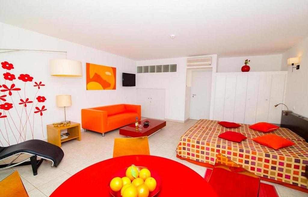 a living room with a bed and a red table at Excellent Golden Apartment in Cabanas de Tavira