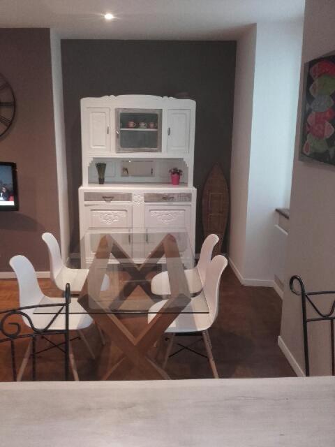 une cuisine avec une table et des chaises et un micro-ondes dans l'établissement Lesneven Appart Nuitee, à Lesneven