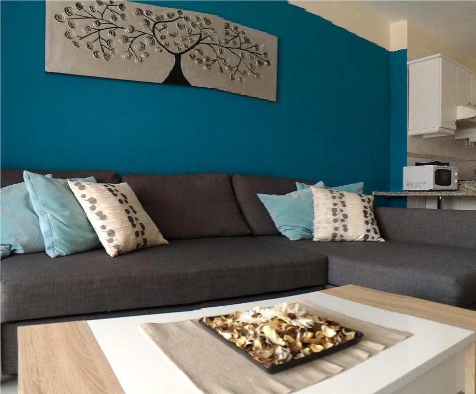 a living room with a brown couch and a blue wall at Almi Cabezo appartamento con terrazza El Médano in El Médano