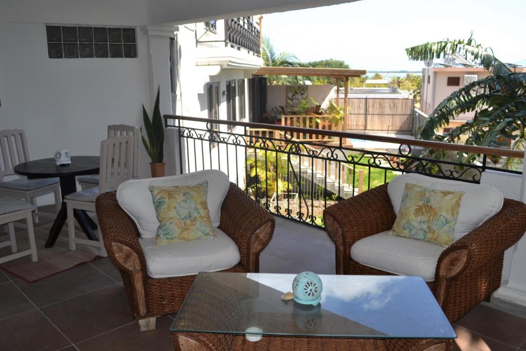 a balcony with two chairs and a table on a balcony at 21LG Le Petit Morne in La Gaulette