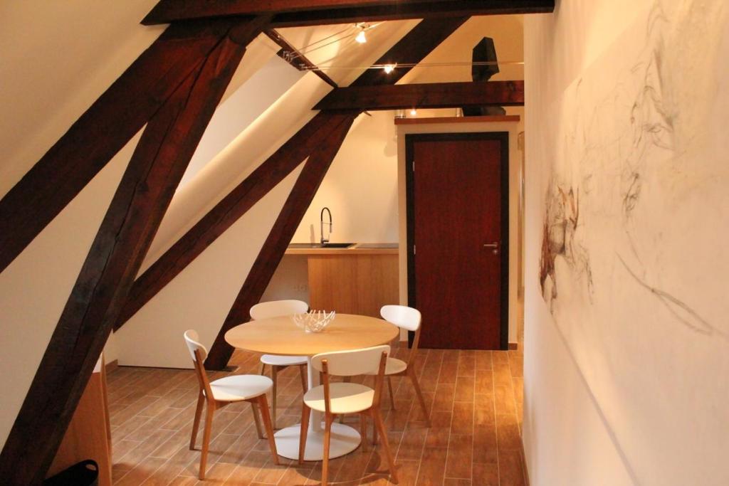 a dining room with a table and white chairs at ART Hôtel in Kaysersberg