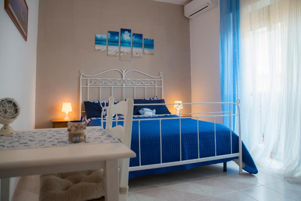 リド・ディ・オスティアにあるB&B Calypsoの青と白のベッドルーム(ベッド1台、テーブル付)