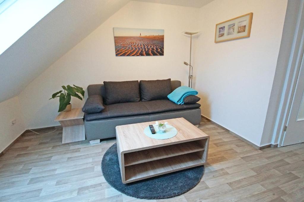 uma sala de estar com um sofá e uma mesa em Ferienwohnung Am Steinkamp em Cuxhaven