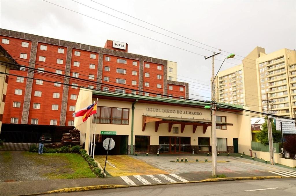 a large building with a flag in front of it at Hotel Diego de Almagro Puerto Montt in Puerto Montt