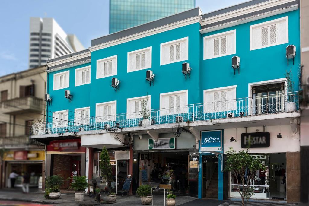 a blue building on a street with buildings at Hotel Paraiso in São Paulo