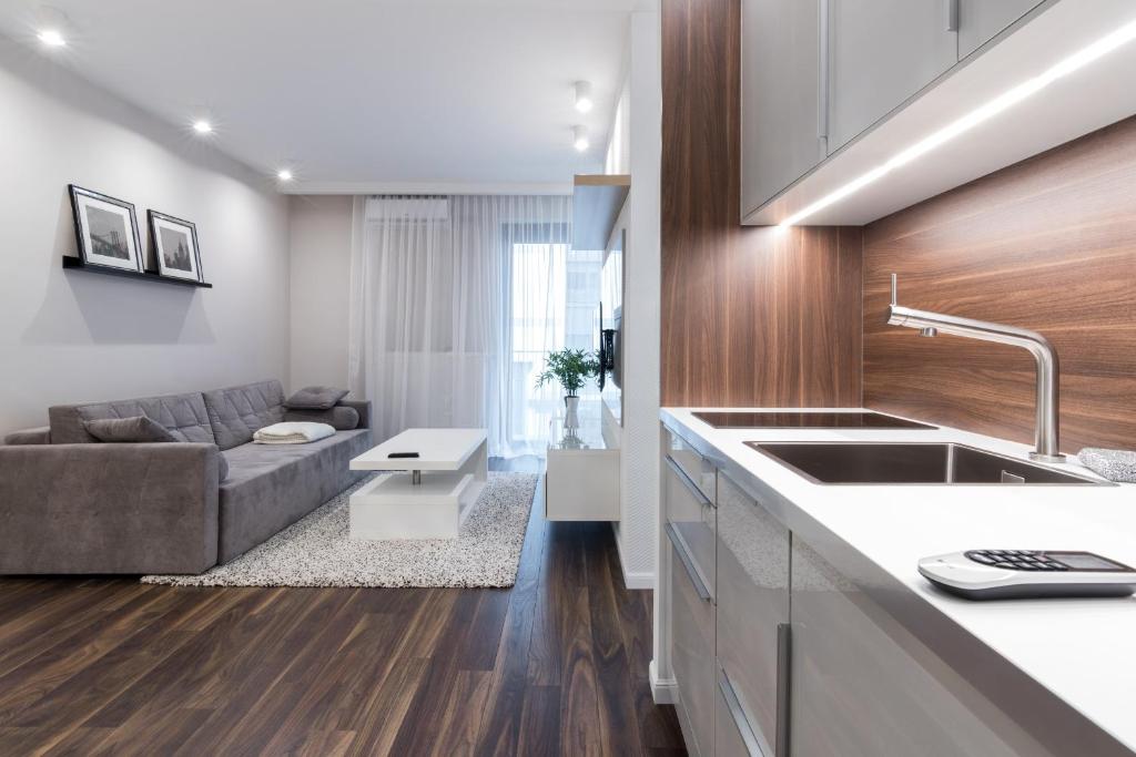 eine Küche und ein Wohnzimmer mit einem Sofa in der Unterkunft GA Luxury Apartments W19 in Krakau