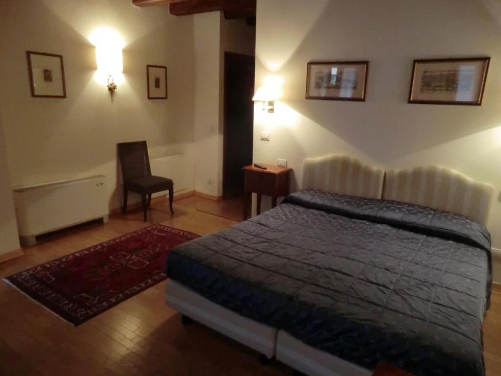 - une chambre avec un lit et une chaise dans l'établissement Valentino b&b, à Portogruaro