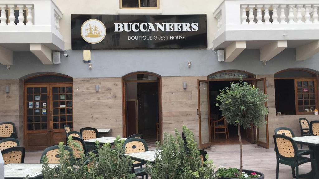 a restaurant with tables and chairs in front of a building at Buccaneers Boutique Guest House in St. Paul's Bay