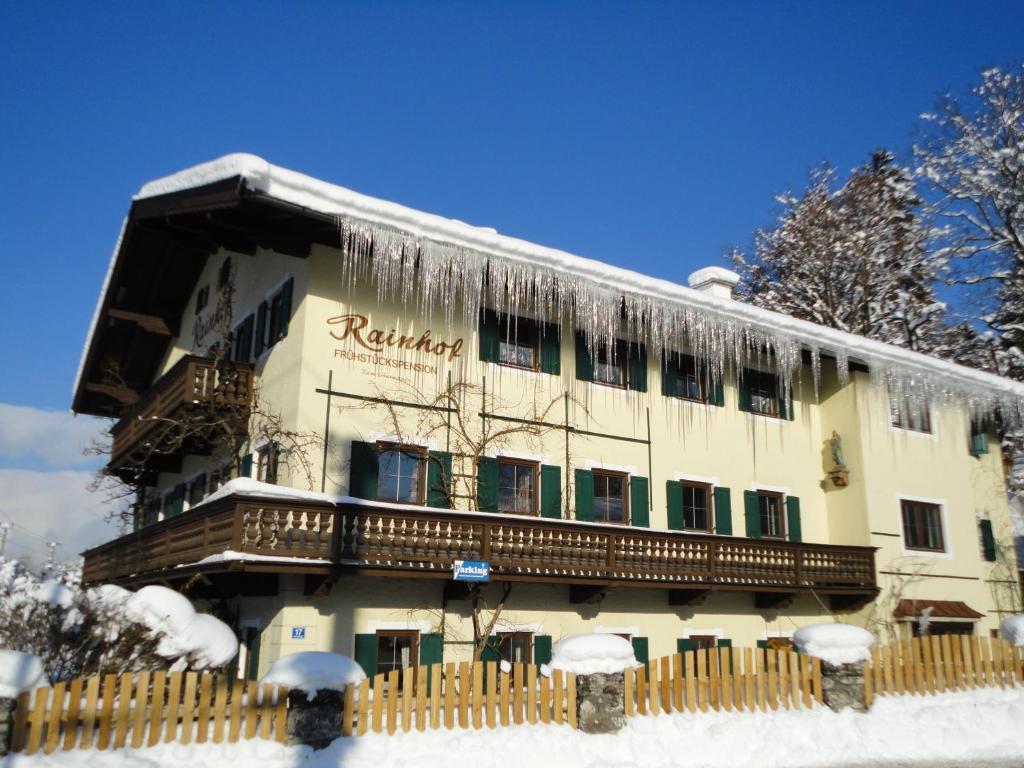 a building with icicles hanging from it in the snow at Pension Rainhof in Kitzbühel