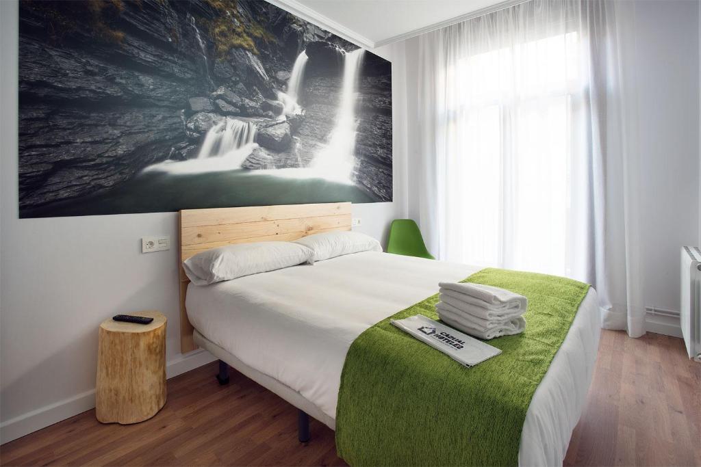 1 dormitorio con 1 cama y una gran pintura en la pared en Casual Serantes, en Bilbao