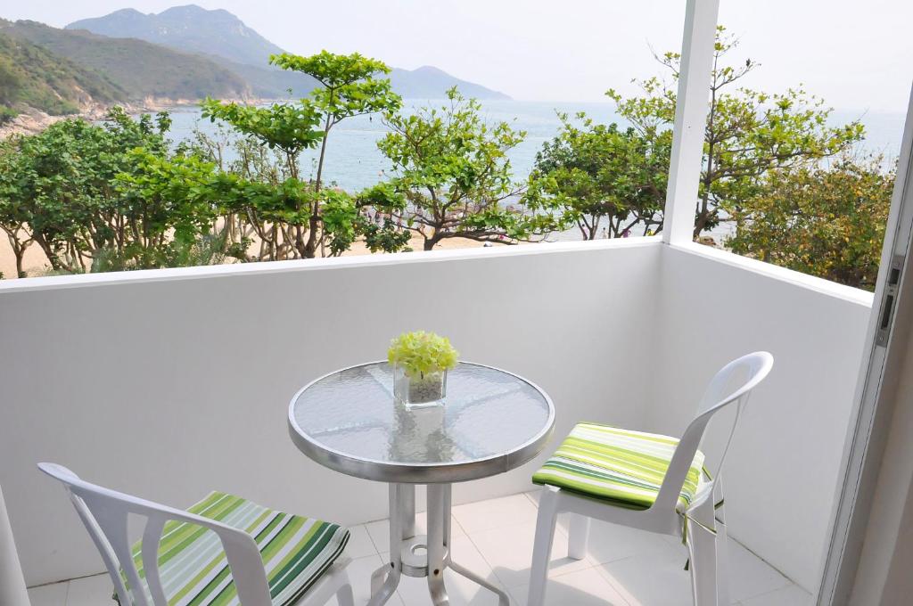 a table and chairs on a balcony with a view of the ocean at Concerto Inn in Hong Kong