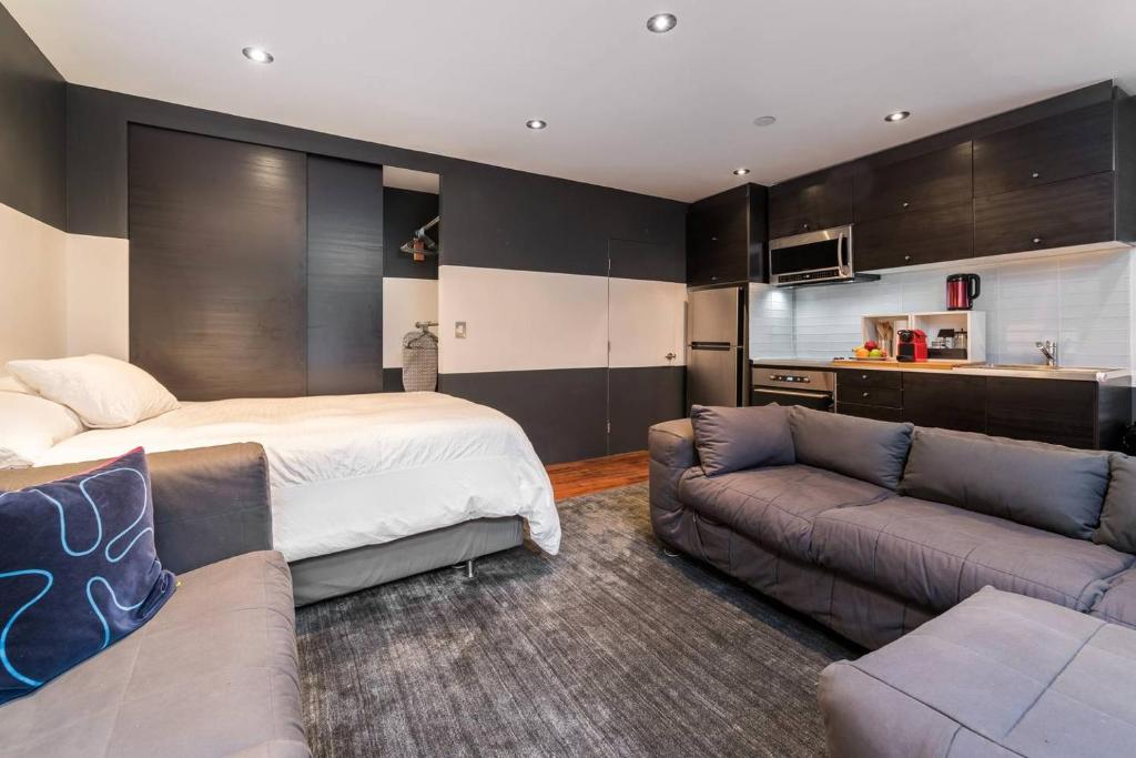 ein Schlafzimmer mit einem Bett und einem Sofa sowie eine Küche in der Unterkunft Palo Alto Cottage by Stanford & Tech Companies in Palo Alto