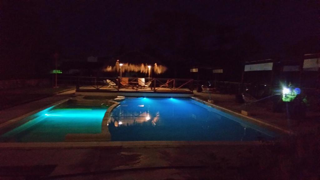 una piscina por la noche con luces azules en La Castellana Hotel de Sierras en Valle Hermoso