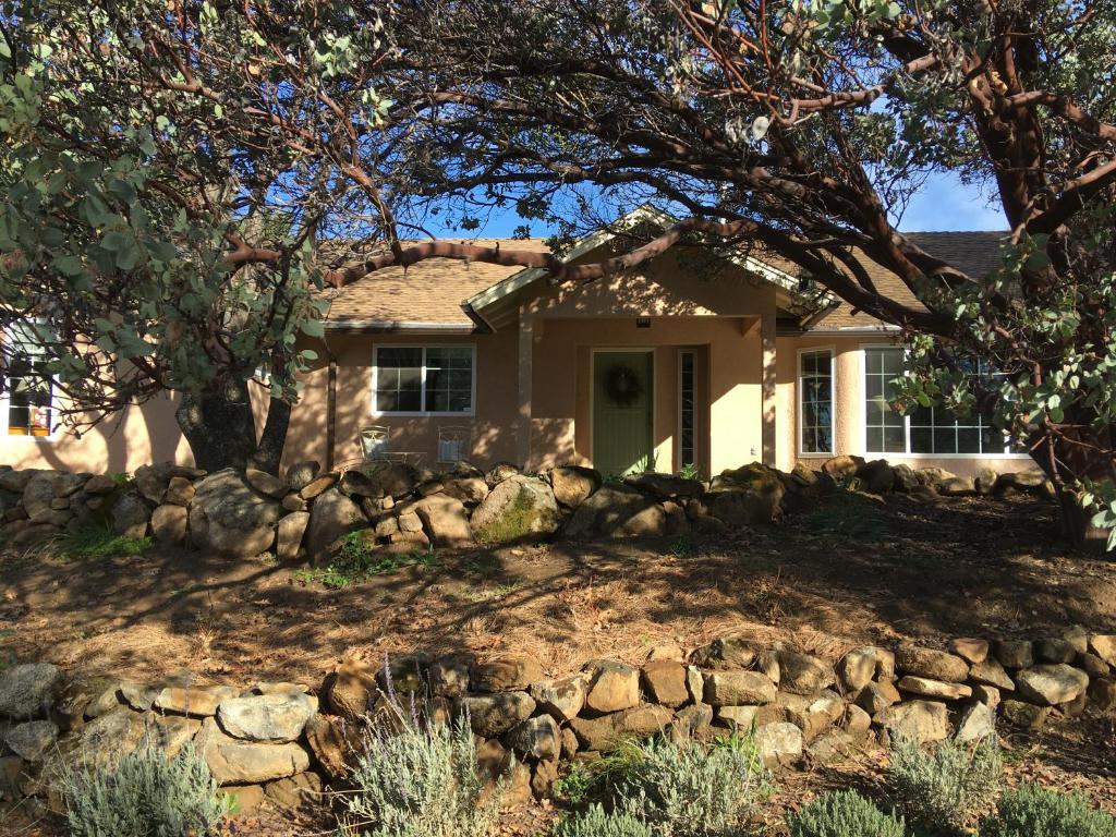 a house with a stone fence in front of it at Foxtail Farm Bed & Breakfast in Ponderosa Basin