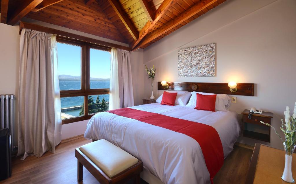 a bedroom with a large bed and a large window at Hotel Concorde in San Carlos de Bariloche