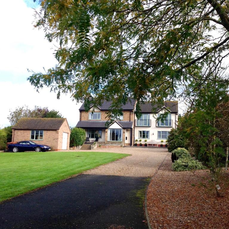 a large house with a green lawn in front of it at 'Tanglemere' in Broadway