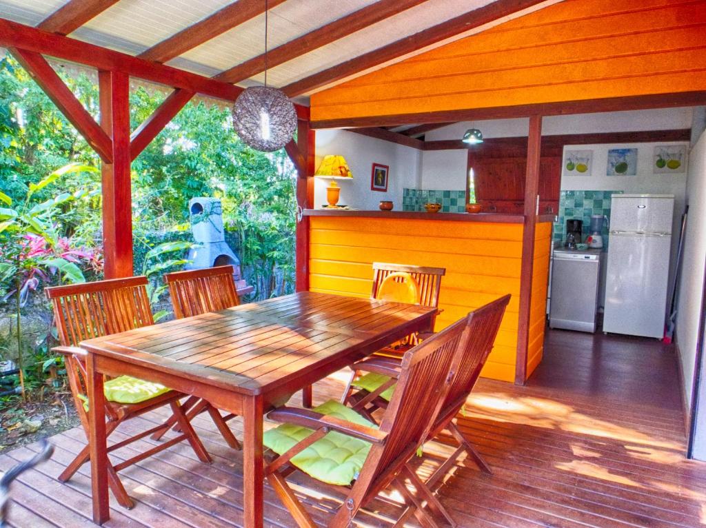 a wooden dining table and chairs on a deck at Le Parc aux Orchidées in Pointe-Noire