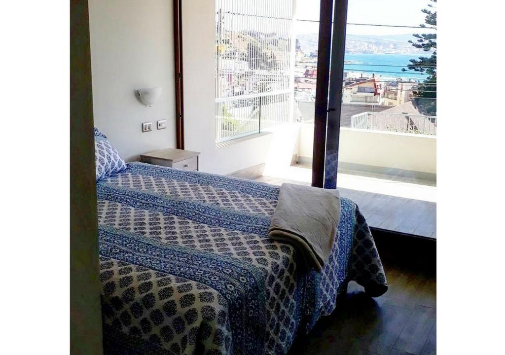 a bedroom with a bed and a large window at Edificio Reñaka Beach 248 in Viña del Mar