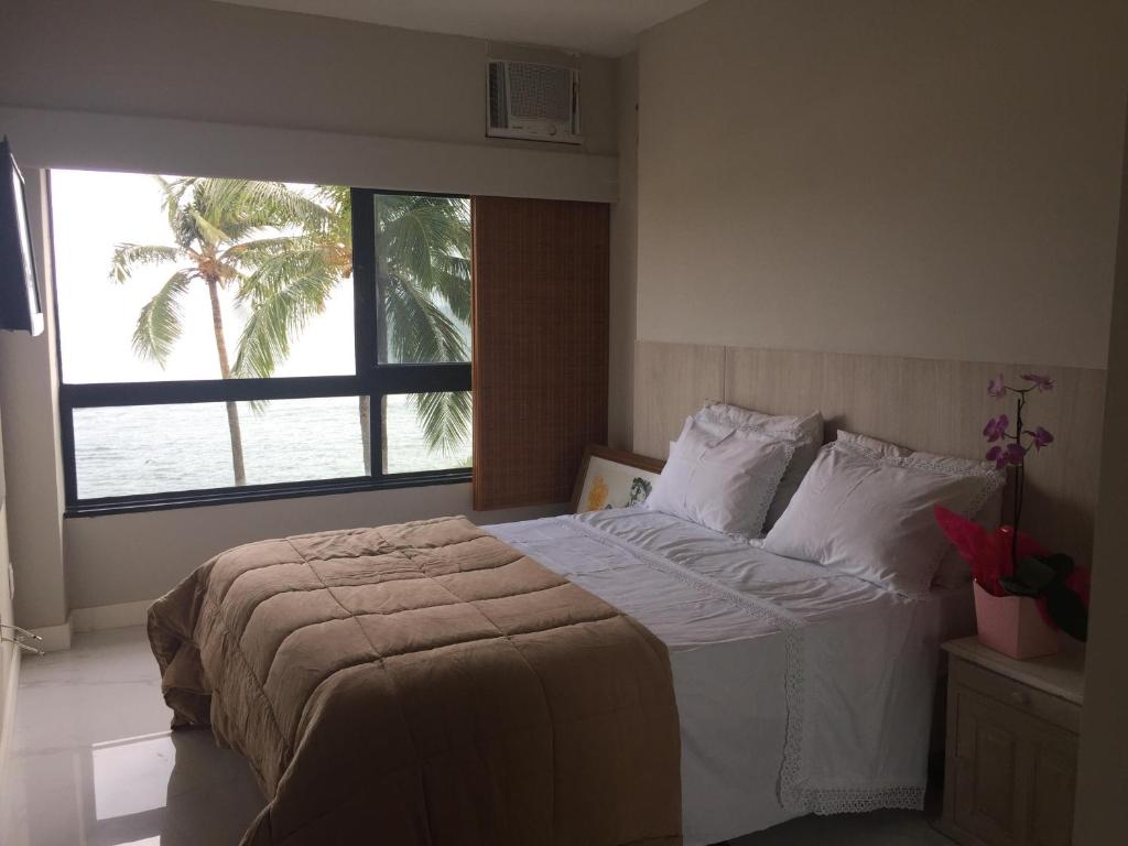 Un dormitorio con una cama con una palmera. en Ondina Apart Hotel en Salvador