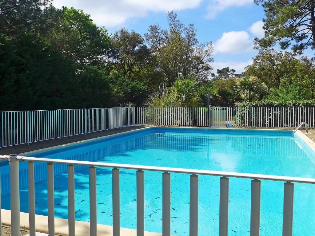 a large blue swimming pool next to a fence at Holiday Home Paradise Océan-5 by Interhome in Capbreton