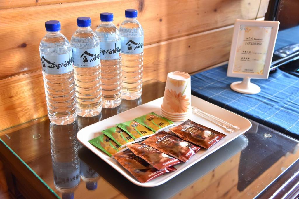 a table with bottles of water and a plate of food at Beverly B&amp;B in Ren&#39;ai