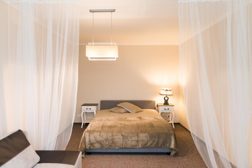 a bedroom with a bed with white curtains at Cozy apartment in Cesis in Cēsis