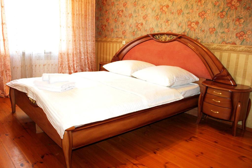 チュメニにある2кв ЦУМ ВОЯЖ Попова7のベッドルーム1室(木製ヘッドボード付)