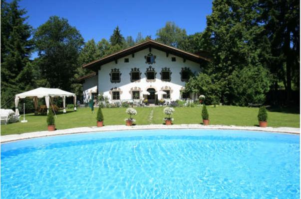 una casa con piscina frente a una casa en Villa Mellon, en Kitzbühel