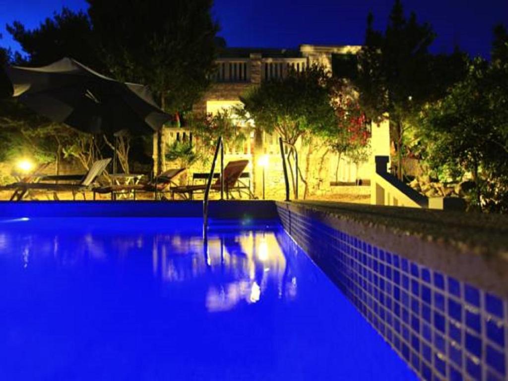a swimming pool at night with a blue illumination at Villa Nova in Vela Luka