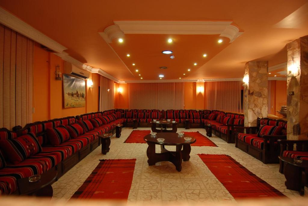 a large waiting room with red chairs and a table at Al Rashid Hotel in Wadi Musa