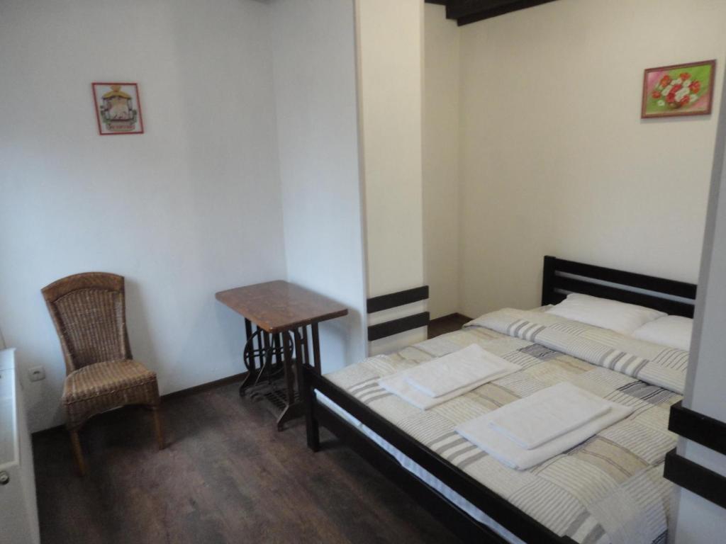 a bedroom with two beds and a small table at Готель "ГОСТЬОВИЙ ДІМ in Stryj" in Stryi