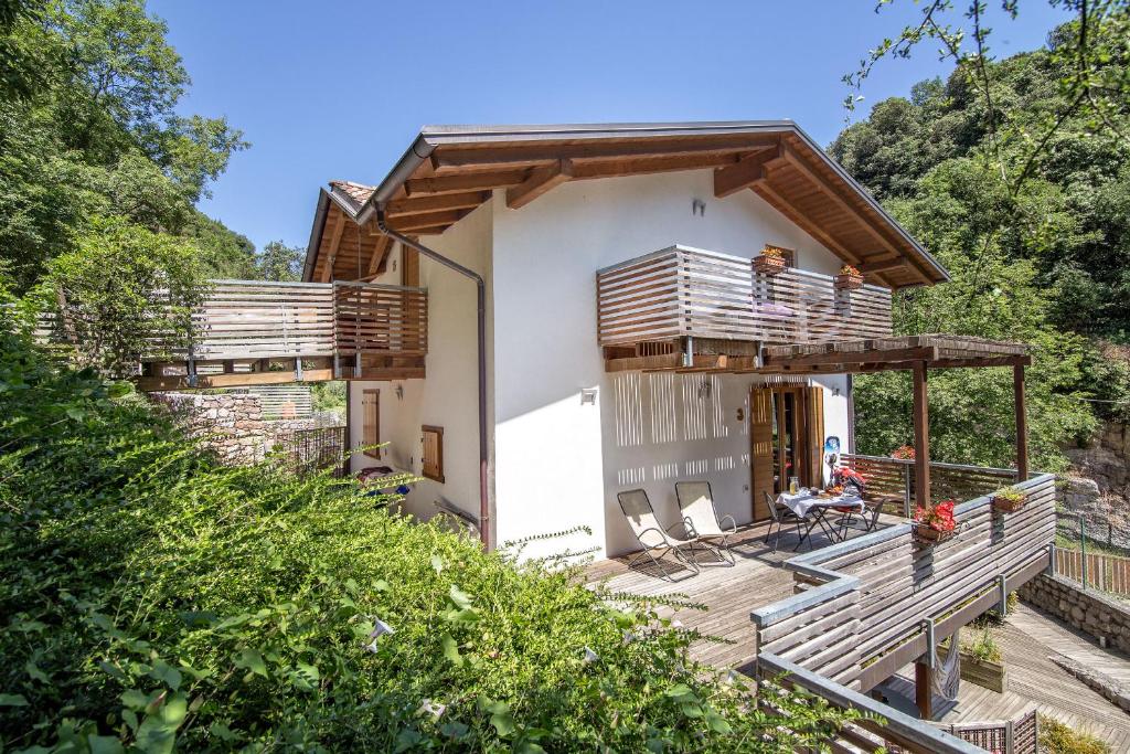 a small house with a balcony and a person sitting on a chair at Sweet Laghel Apartments in Arco