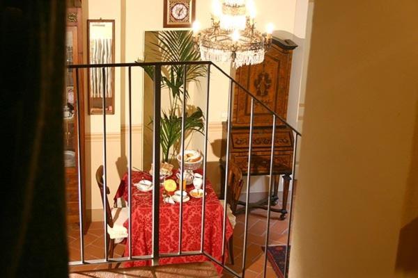 een woonkamer met een tafel en een smeedijzeren hek bij Dolce Maria in Cortona