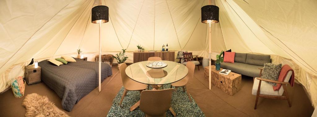 a room with a bed and a table in a tent at Camp Boutique in Gaulverjabær