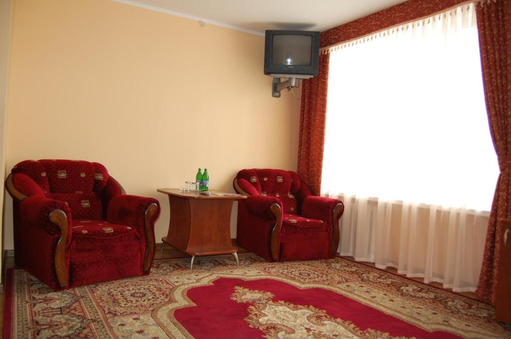 two chairs and a table in a room with a window at RP hotel Лісова пісня in Kovel