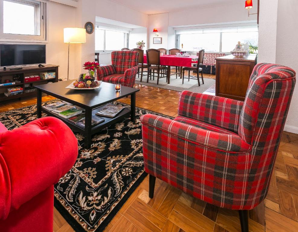 uma sala de estar com cadeiras vermelhas e uma mesa em Apartamento Vintage 1 em Porto