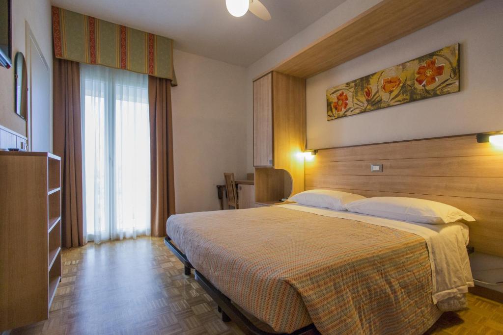 チェゼナーティコにあるHotel Donatelloのベッドルーム1室(大型ベッド1台付)