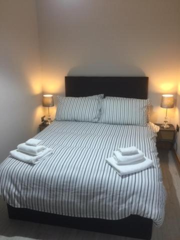 a bedroom with a large bed with towels on it at Dark Hedges Cottage in Ballycastle