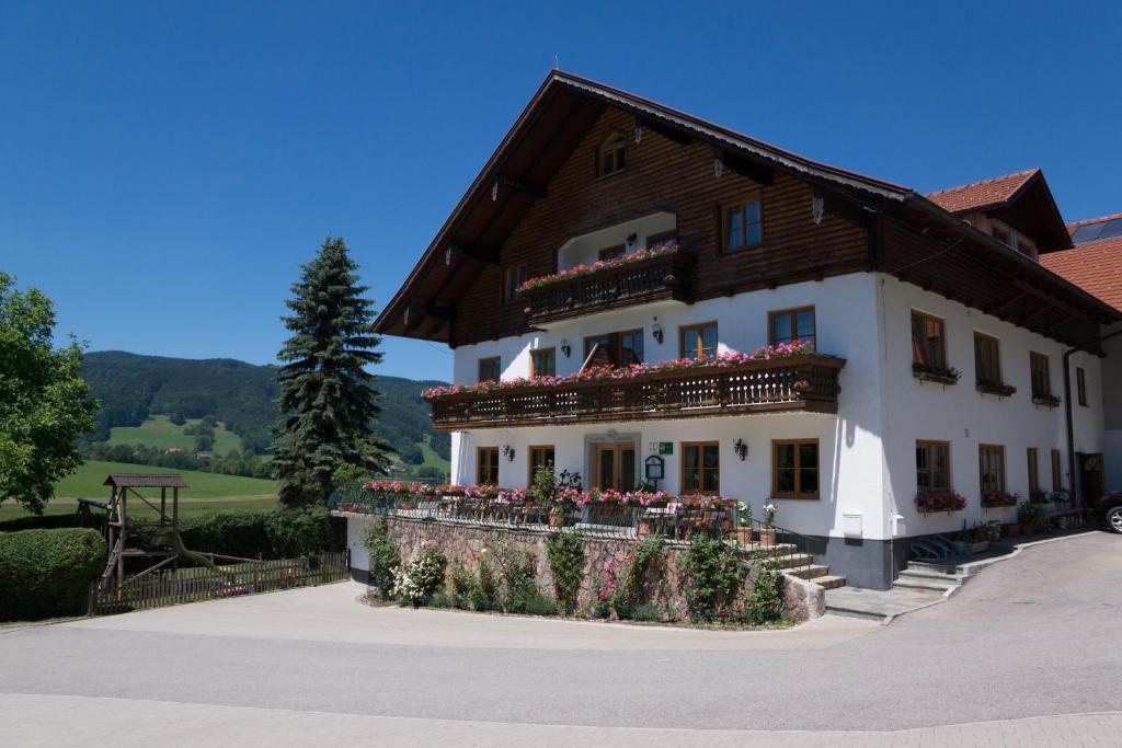 een groot wit gebouw met bloemen ervoor bij Bauernhof Kasleitner in Zell am Moos