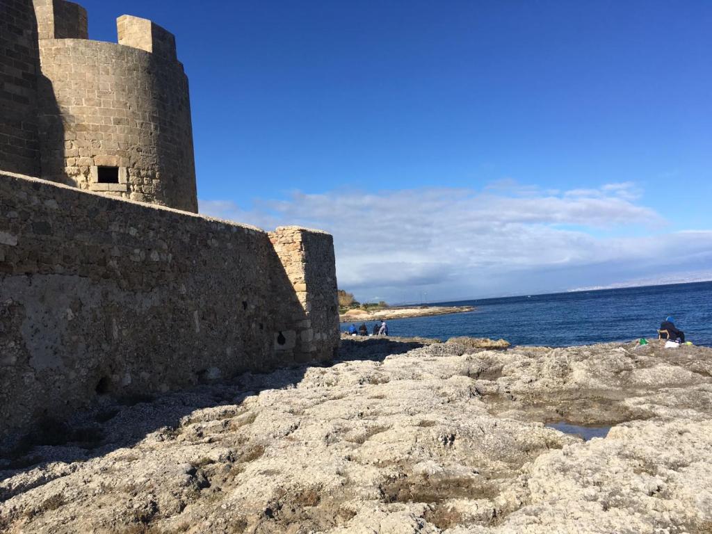 ブルコリにあるLa Casa Accanto il Castelloの海を背景にした海辺の建物